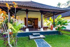 a house with a porch with a bed and a room at Villa Taman di Blayu by AGATA in Tabanan