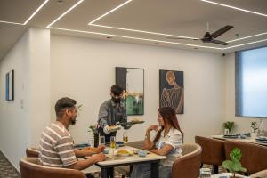 a group of people sitting at tables in a restaurant at Perfectstayz Premium Dehradun at Rajpur road in Dehradun +125 photos