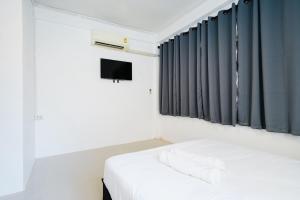 a bedroom with a white bed and a television at zNAP Ekkamai BTS เอกมัย 42 in Bangkok