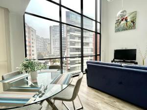 a living room with a glass table and a couch at ESPECTACULAR LOFT in Quito