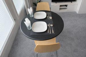 a black table with white plates and silverware on it at Nord Heaven in Turku +3 photos
