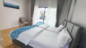 a bedroom with a large white bed with a window at บ้านออมPool villa บางแสน sin in Ban Bang Saen (1) +21 photos
