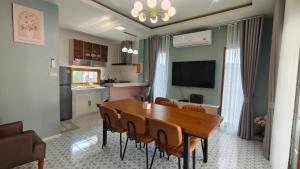 a kitchen and dining room with a table and chairs at บ้านออมPool villa บางแสน sin in Ban Bang Saen (1)