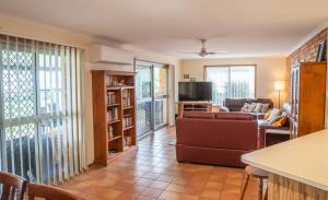 ein Wohnzimmer mit Sofa und Fernseher in der Unterkunft Conway in Burrum Heads