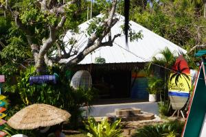 a house with a white roof and a tree at La Provinzia Exclusive Use - 3 Air-Conditioned Rooms 3 Fan Cooled Huts Good for 12 People in Camotes Islands