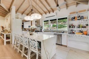 a kitchen with white cabinets and a large island at Villa Serena Water Island in Water Island