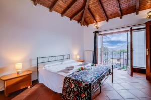 a bedroom with a bed and a large window at Casa al Castello in Leggiuno with Garden - Happy Rentals in Leggiuno
