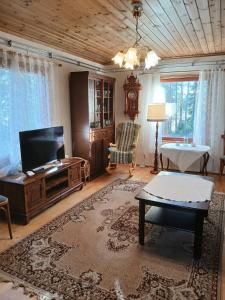 a living room with a tv and a coffee table at Villa Sukuviiri in Vimpeli
