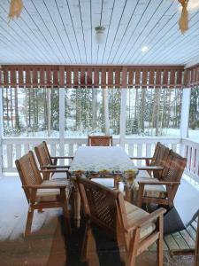 a table and chairs on a porch with snow on it at Villa Sukuviiri in Vimpeli