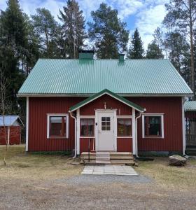 a red house with a white door and a green roof at Villa Sukuviiri in Vimpeli