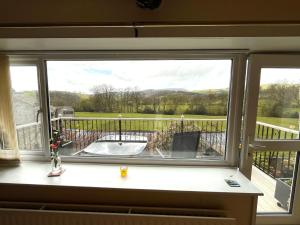 a window with a view of a golf course at Tilly Cottage - overlooking Pendle Hill in Barrowford