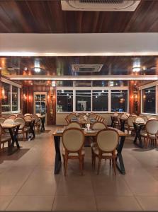 a restaurant with wooden tables and chairs and windows at Hotel Tapovan Hills in Rishīkesh