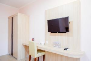 a room with a desk with a tv on a wall at RedDoorz near Gejayan 3 in Yogyakarta
