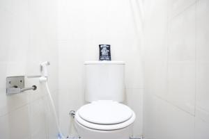 a bathroom with a toilet with a picture on top of it at RedDoorz near Gejayan 3 in Yogyakarta +20 photos