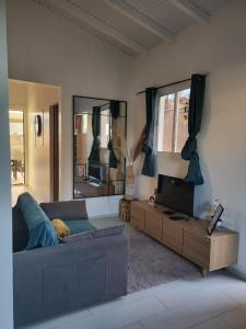 a living room with a couch and a tv at Paradise House in Saint-François