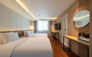 a hotel room with a large bed and a television at Adena Hotel in Busan