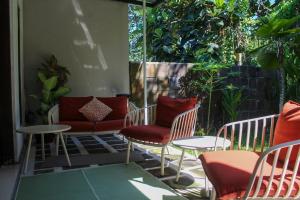 a patio with chairs and tables on a patio at Charming 2BR Home Close to Pering Beach Gianyar in Saba