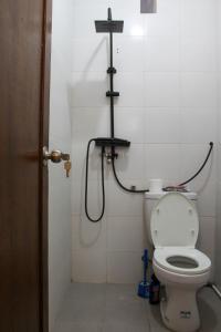 a bathroom with a toilet with a cross on the wall at Charming 2BR Home Close to Pering Beach Gianyar in Saba +50 photos
