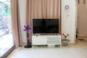 a flat screen tv sitting on top of a white cabinet at Charming 2BR Home Close to Pering Beach Gianyar in Saba