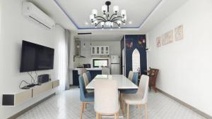 a dining room with a table and chairs and a tv at บ้านออมPool villa บางแสน om in Ban Bang Saen (1)