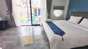 a bedroom with a large bed and a swimming pool at บ้านออมPool villa บางแสน om in Ban Bang Saen (1)