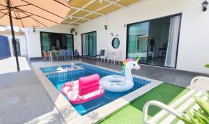 a pool with a unicorn and two chairs and an umbrella at บ้านออมPool villa บางแสน om in Ban Bang Saen (1) +9 photos