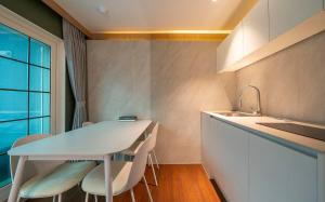 a kitchen with a table and chairs and a sink at Adena Hotel in Busan +28 photos