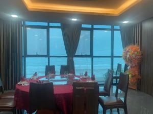 a dining room with a table and a large window at Hải Phát Hotel in Du Xuyên