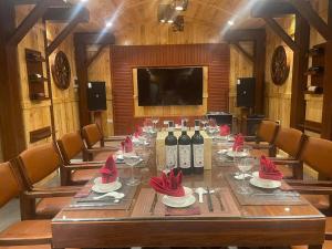 a long wooden table with wine bottles and red bows at Hải Phát Hotel in Du Xuyên