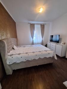ein Schlafzimmer mit einem Bett und einem Fernseher in der Unterkunft Duplex Confort Hd in Hunedoara