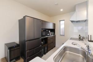 a kitchen with a sink and a stainless steel refrigerator at ev itoshima in Itoshima