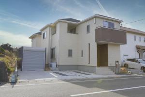 a large white house with a garage at ev itoshima in Itoshima