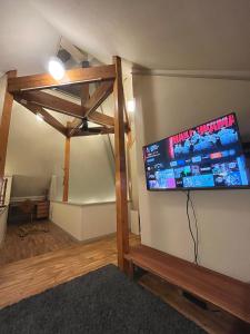 a living room with a flat screen tv on a wall at ROHAUS Entire Home with private Hot Spring in Shiraoi