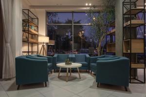 a waiting room with blue chairs and a table at City Park Hotel in Skopje