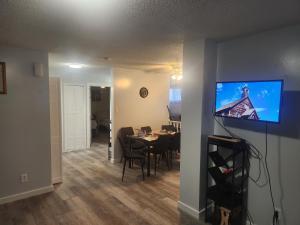a living room and dining room with a table and a television at Sword and Dove Rental in Spirit River