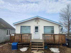 a small white house with two decks at Sword and Dove Rental in Spirit River