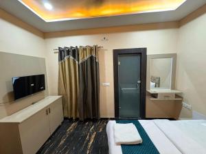 a room with a bed and a tv and a bathroom at Hotel Tapovan Hills in Rishīkesh