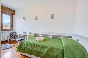 a bedroom with a green bed and a desk at Casa Alexander - Lake Garda Apartment with Terrace - Happy Rentals in Riva del Garda