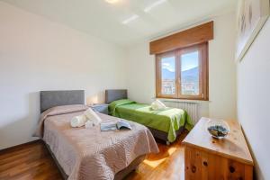 a bedroom with two beds and a window at Casa Alexander - Lake Garda Apartment with Terrace - Happy Rentals in Riva del Garda +17 photos