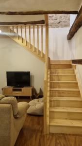 a living room with a staircase and a television at Casa Rural Doña Aba in Espinosa de los Monteros