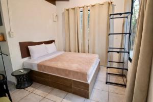 a small bedroom with a bed and a ladder at Green Point Nosara in Nosara +4 photos