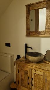 a bathroom with a sink on top of a wooden cabinet at Casa Rural Doña Aba in Espinosa de los Monteros