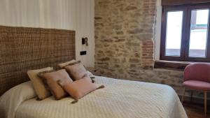 a bedroom with a bed with a brick wall at Casa Rural Doña Aba in Espinosa de los Monteros