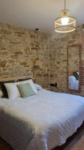 a bedroom with a bed and a stone wall at Casa Rural Doña Aba in Espinosa de los Monteros +12 photos