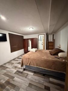 a bedroom with a large bed and a tile floor at Apartamento Xeul in Quetzaltenango