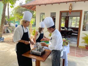 a man and two women in chefs hats preparing food at Okay 1 Villa in Siem Reap +130 photos
