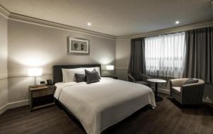 a hotel room with a bed and a chair at Kensington Hotel Yeouido in Seoul