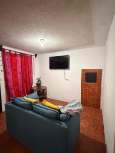 a blue couch in a living room with a flat screen tv at Apartamento Xeul in Quetzaltenango