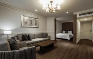 a living room with a couch and a bed at Kensington Hotel Yeouido in Seoul