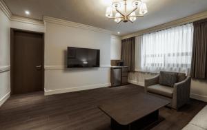 a living room with a television and a chair at Kensington Hotel Yeouido in Seoul